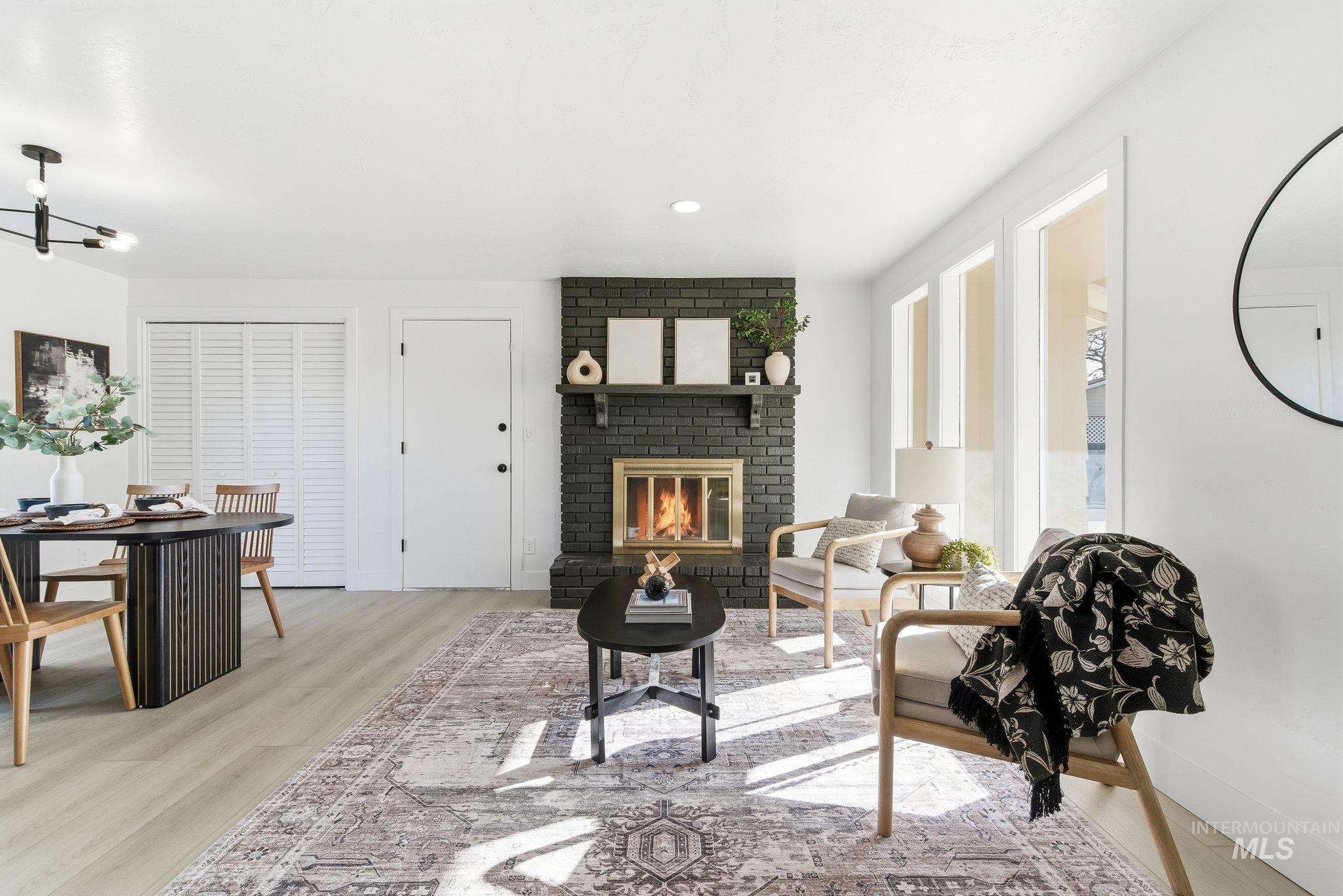 Living room with a fireplace, light wood finished floors, and recessed lighting