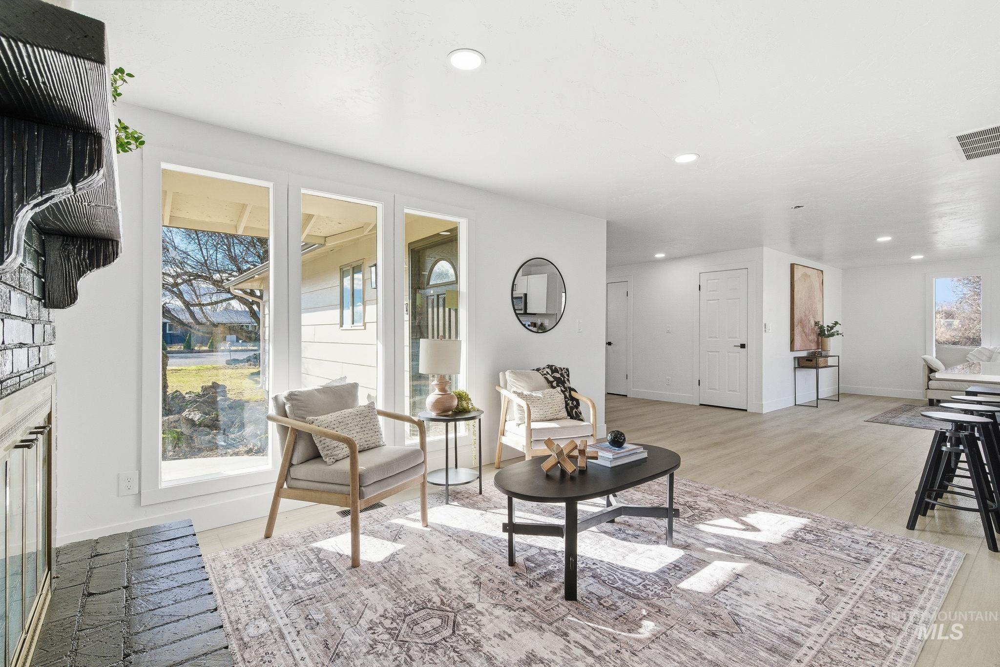 Living area featuring light wood-style floors, recessed lighting, and a fireplace