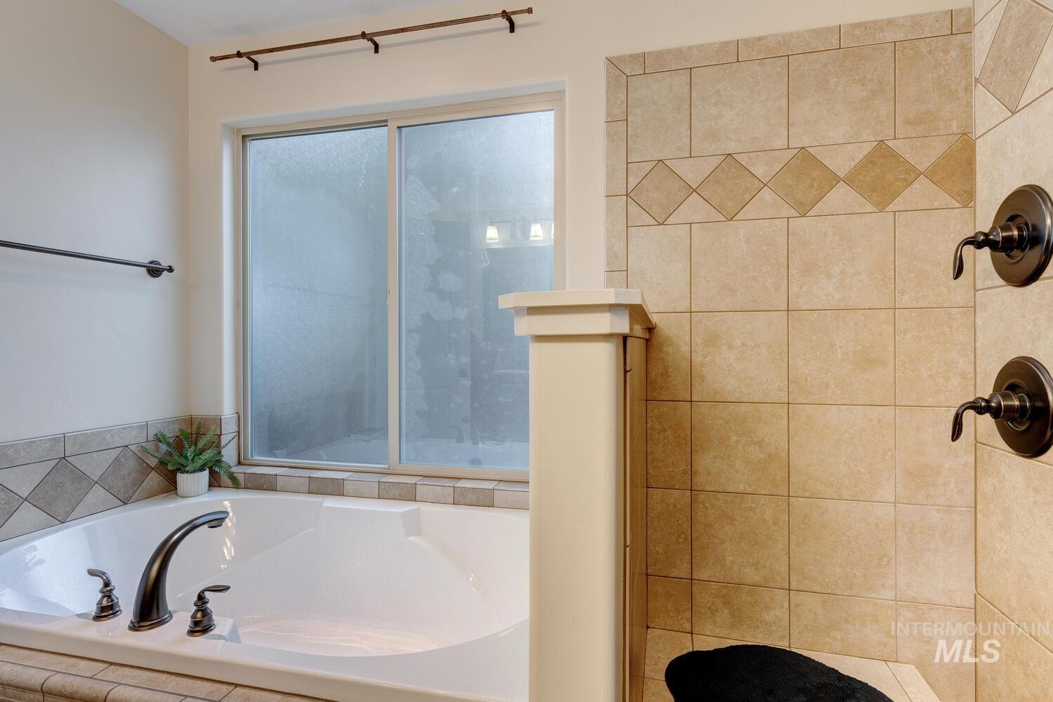 Bathroom featuring a garden tub and a tile shower