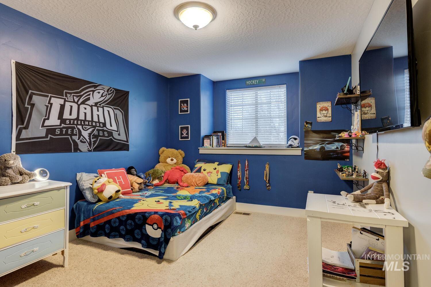 Bedroom featuring a textured ceiling and carpet