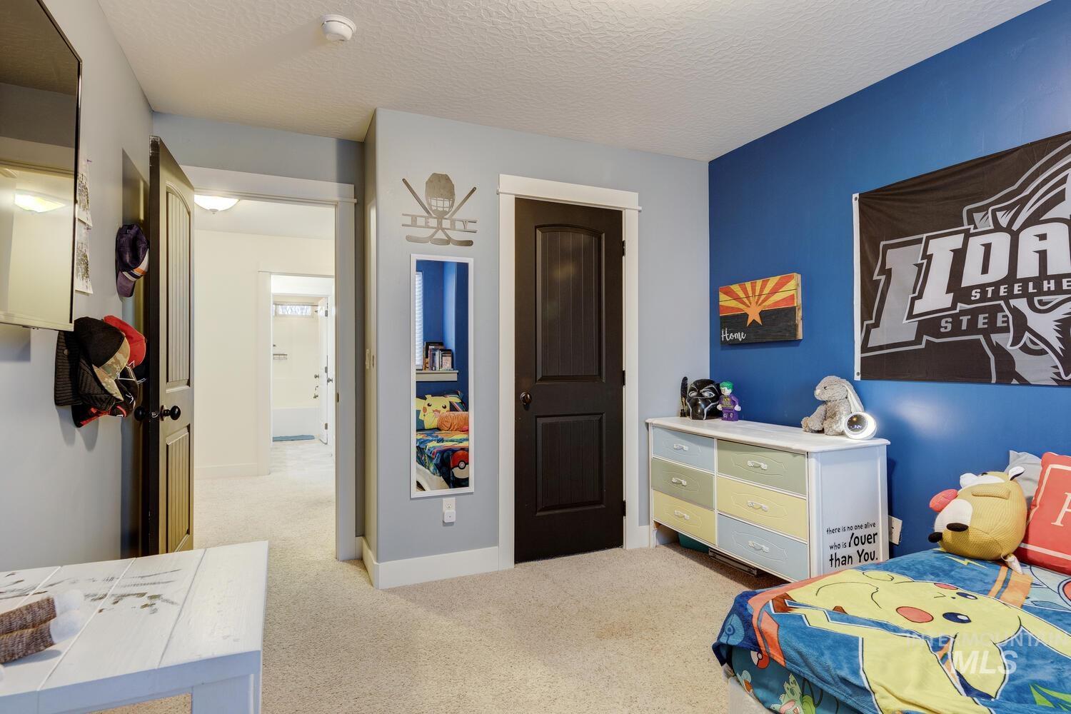 Bedroom with light carpet and a textured ceiling