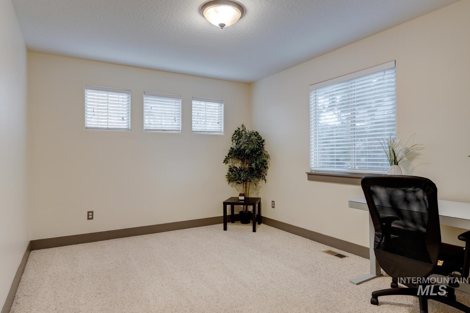 Carpeted office space featuring baseboards