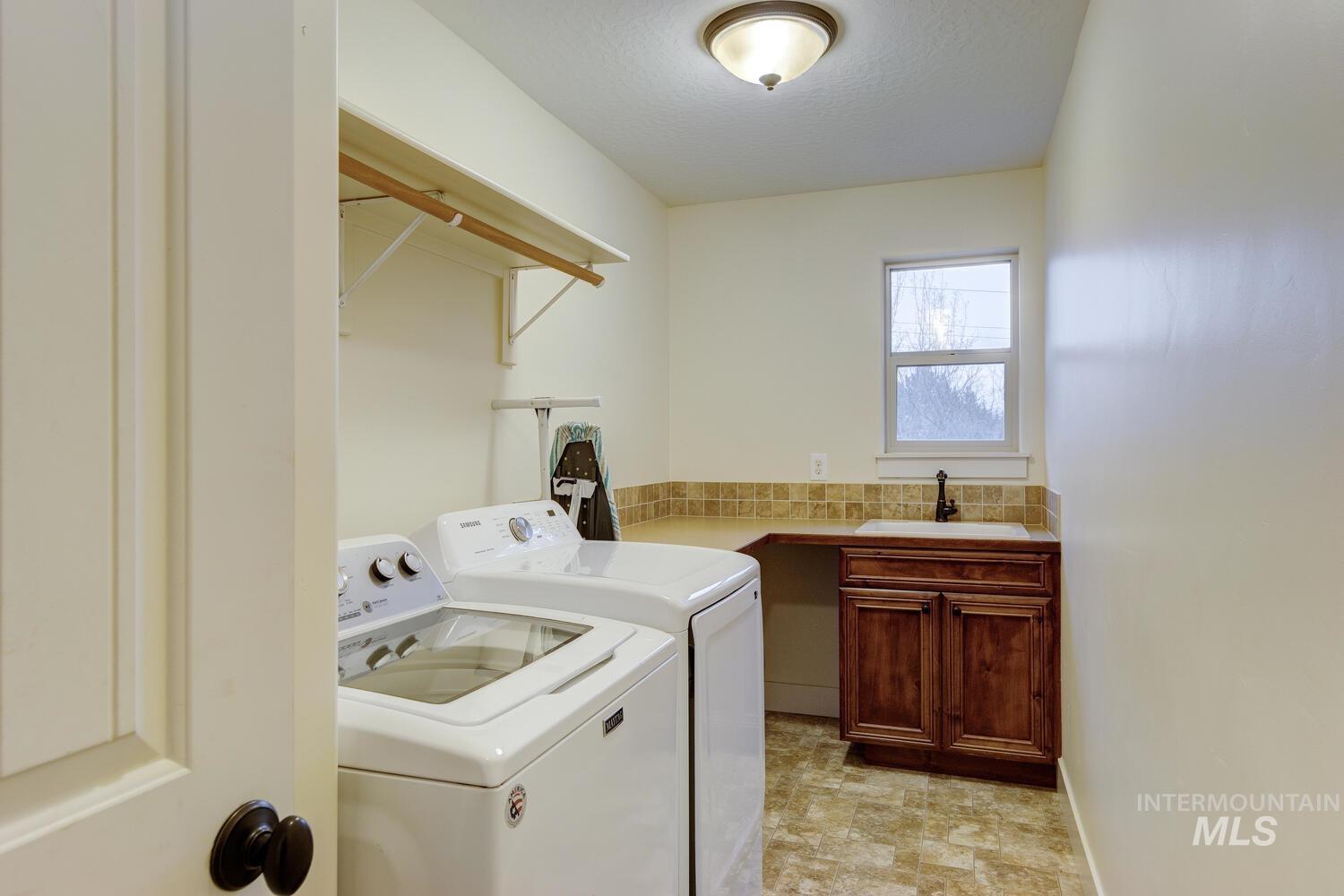 Washroom with washing machine and clothes dryer and a textured ceiling