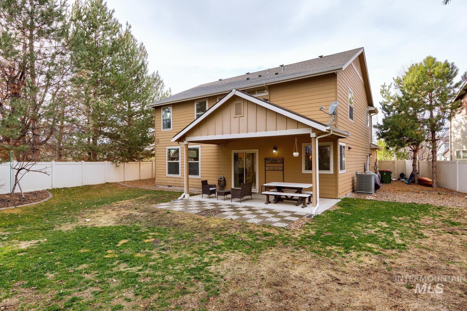 Back of property with a fenced backyard, a patio, and board and batten siding