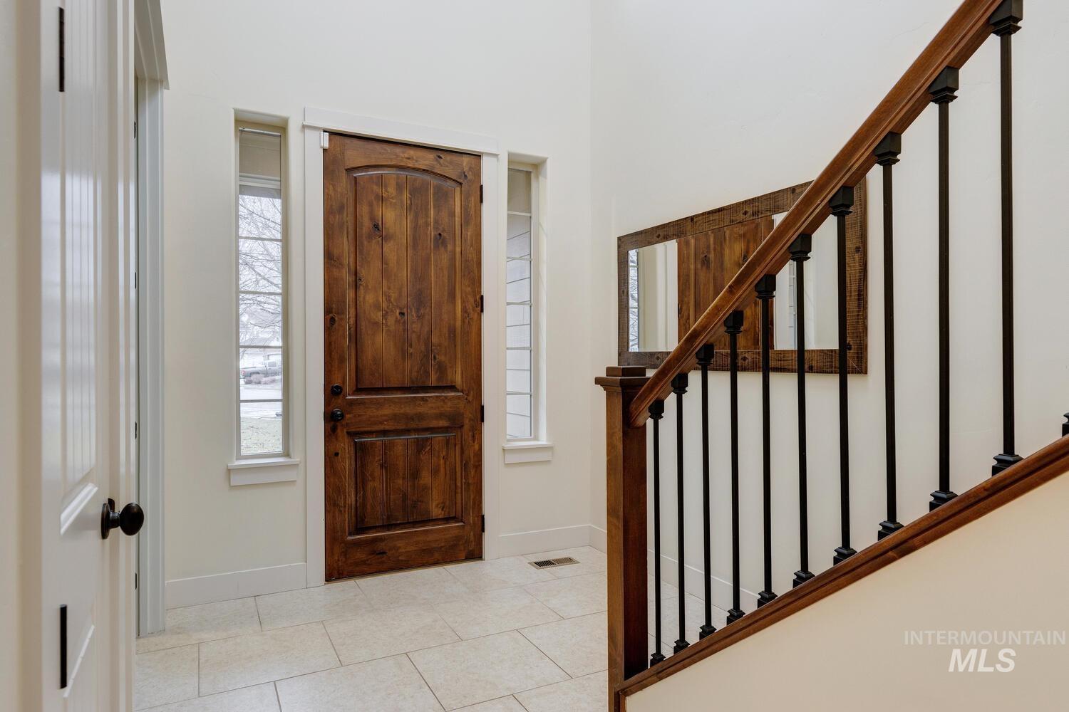 Entryway with tile patterned flooring and baseboards