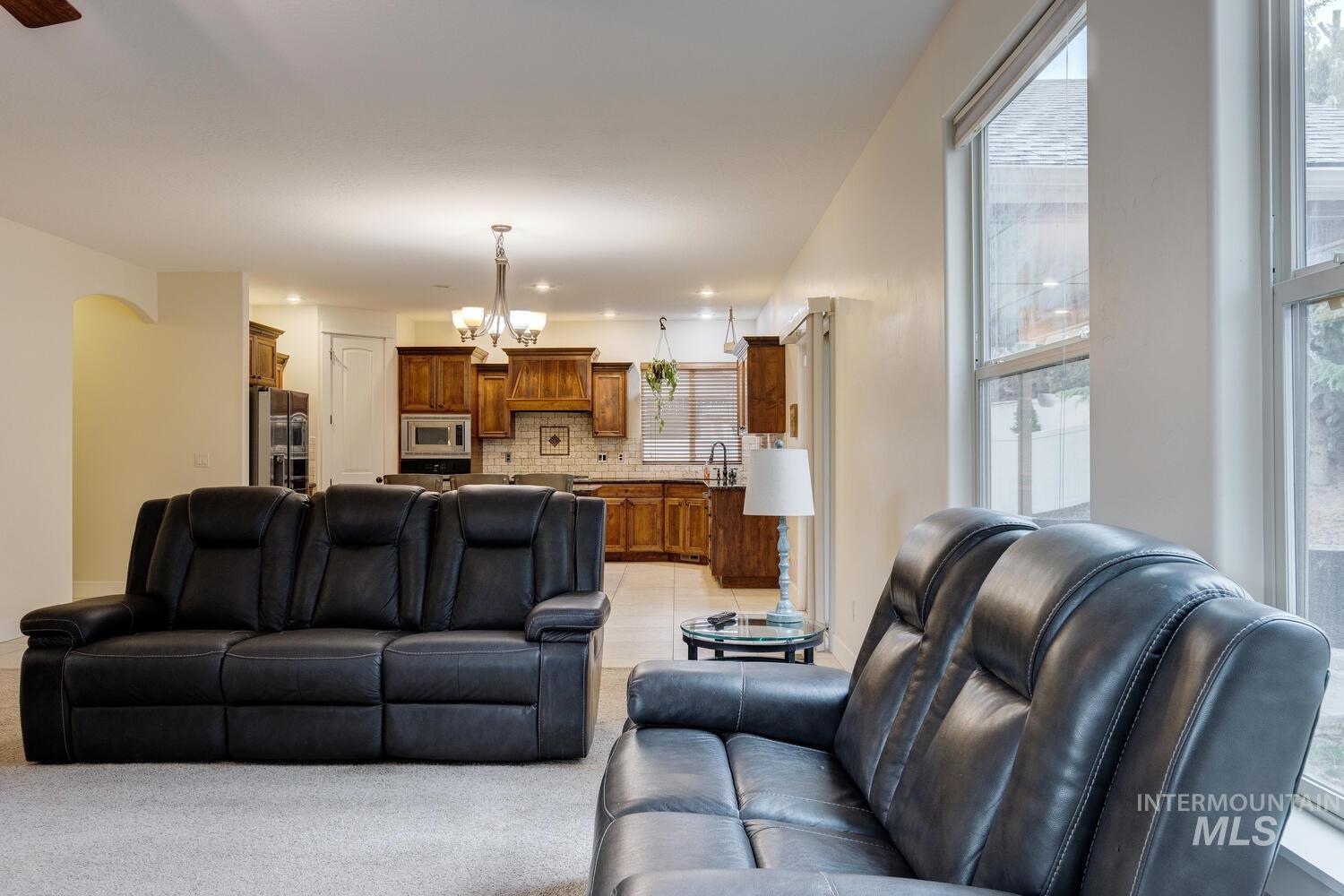 Living area featuring a chandelier, recessed lighting, light tile patterned floors, and light carpet