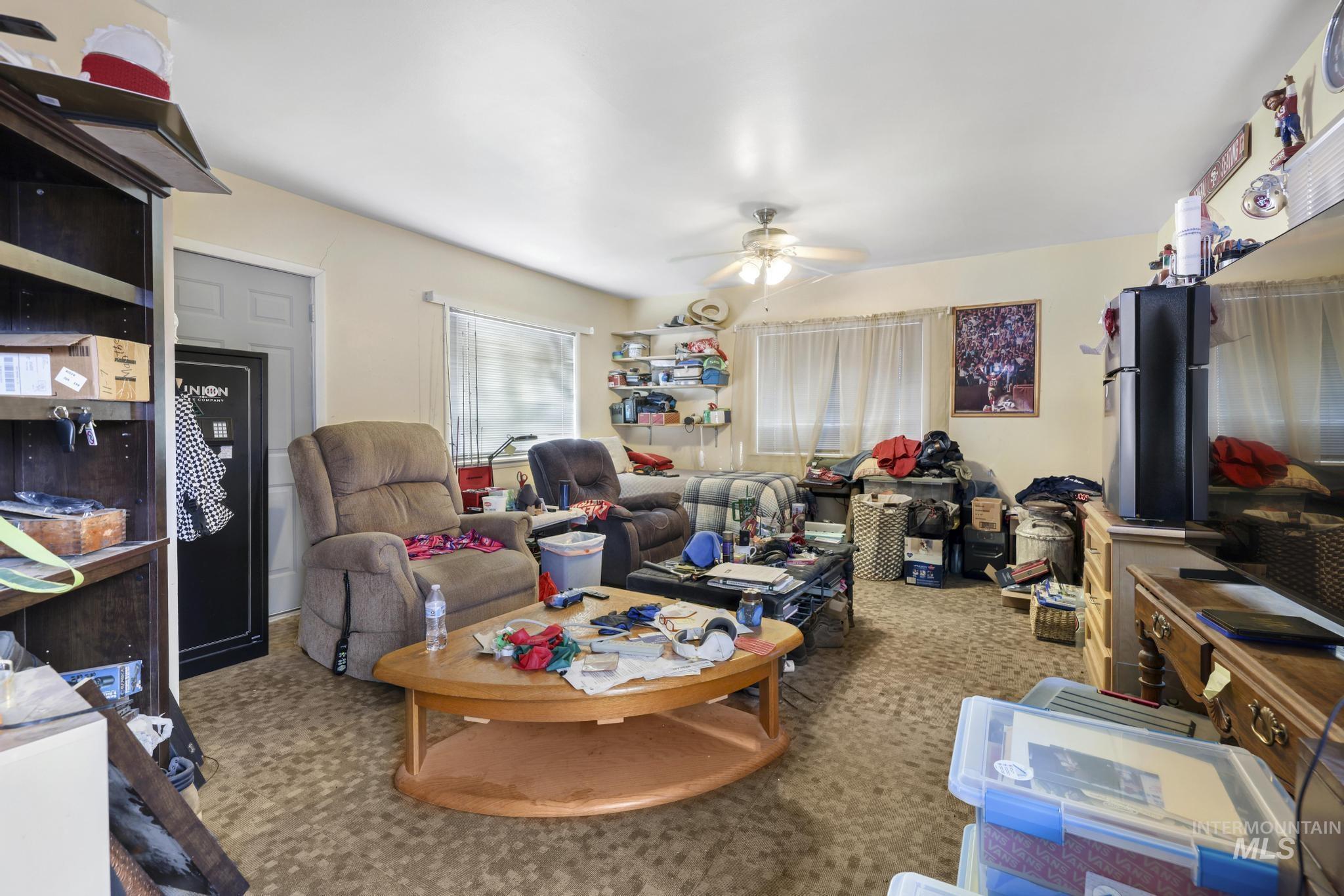 Carpeted living area featuring a ceiling fan