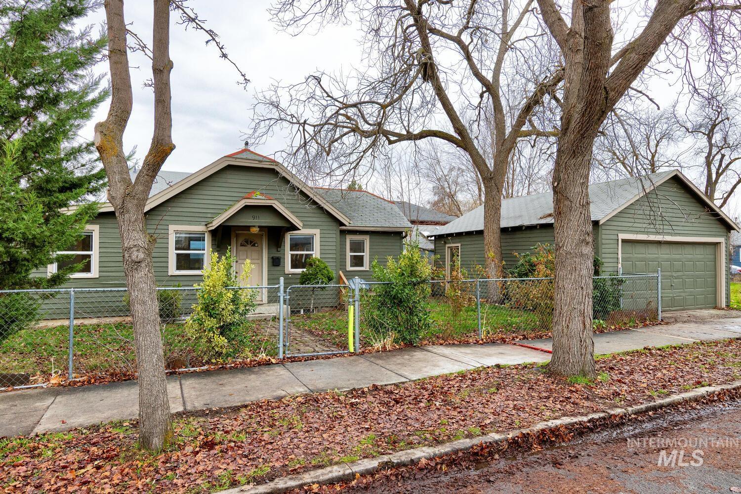 Bungalow-style home featuring a fenced front yard, a garage, and a gate