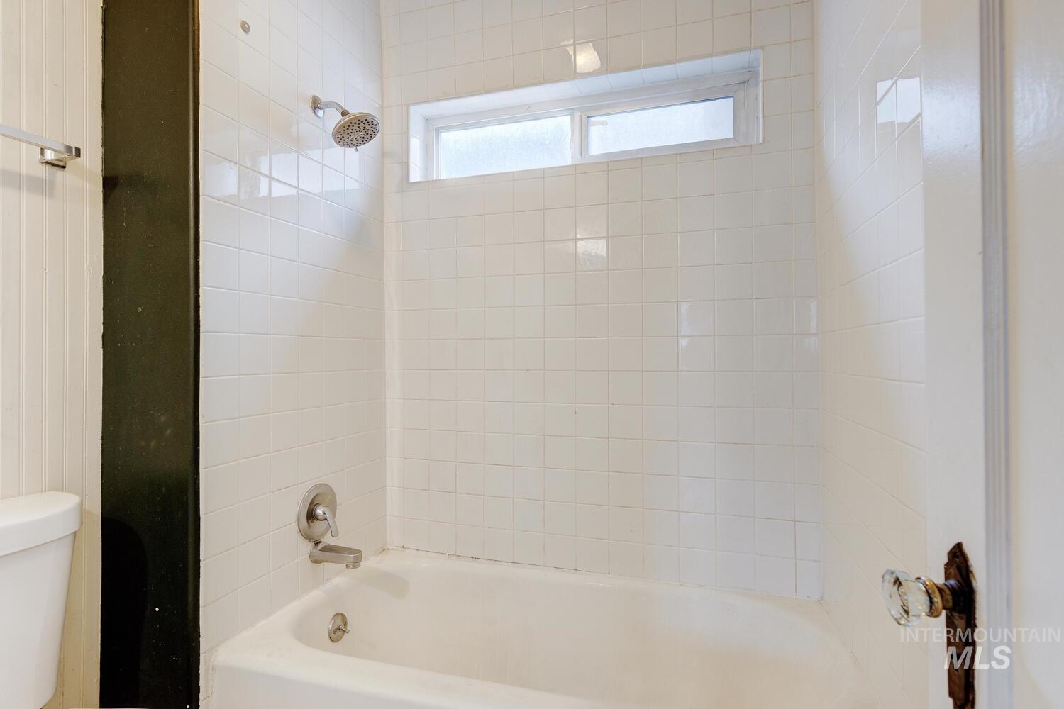 Bathroom featuring shower / tub combination and toilet