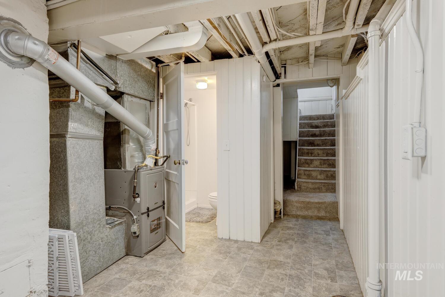 Unfinished below grade area with stairway and heating unit