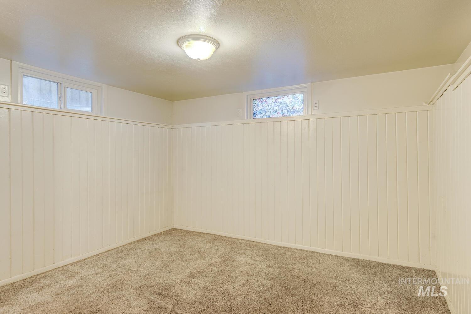 Below grade area with a textured ceiling and carpet flooring