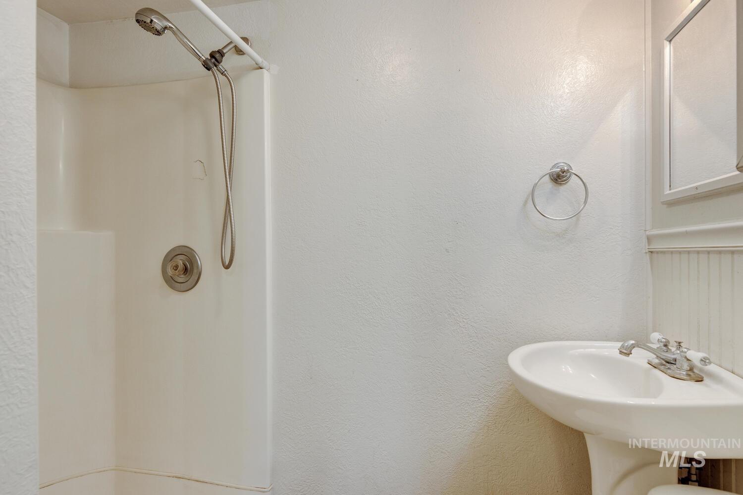 Full bath with a shower and a textured wall