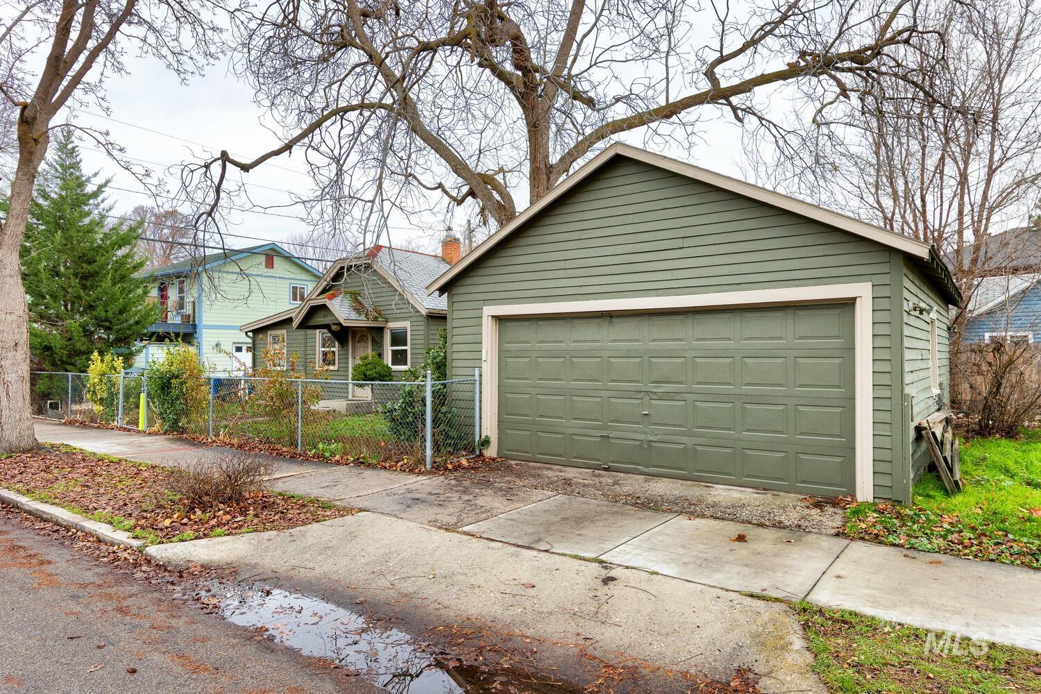 View of front facade with an outdoor structure, a chimney, and a detached garage