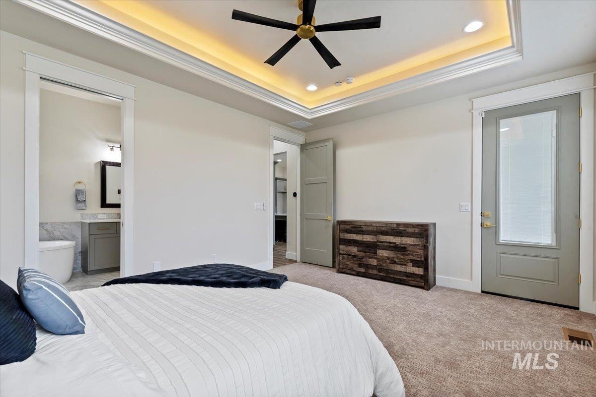 Bedroom featuring carpet floors, recessed lighting, a tray ceiling, and a ceiling fan