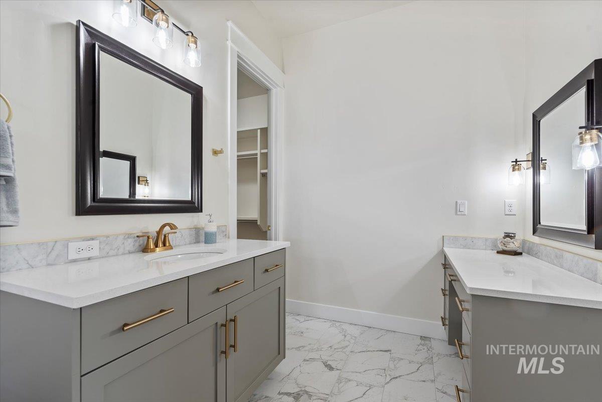 Full bathroom with vanity and light marble finish flooring
