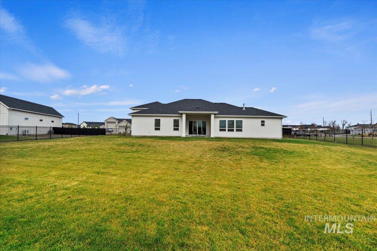 Rear view of property with a fenced backyard and a patio