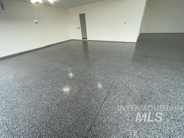 Unfurnished room featuring light speckled floor