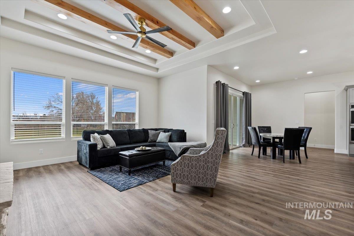 Living area with recessed lighting, light wood-type flooring, beamed ceiling, and ceiling fan