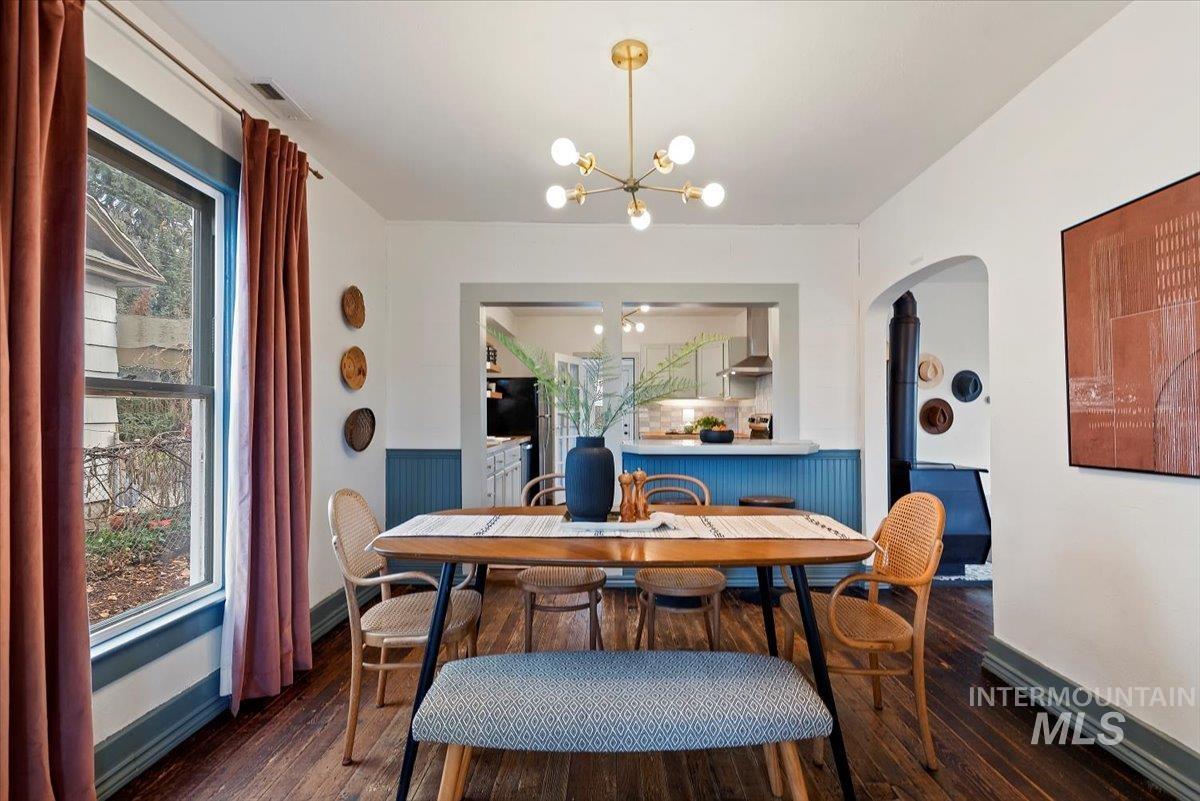 Dining room featuring a chandelier and dark wood-style flooring