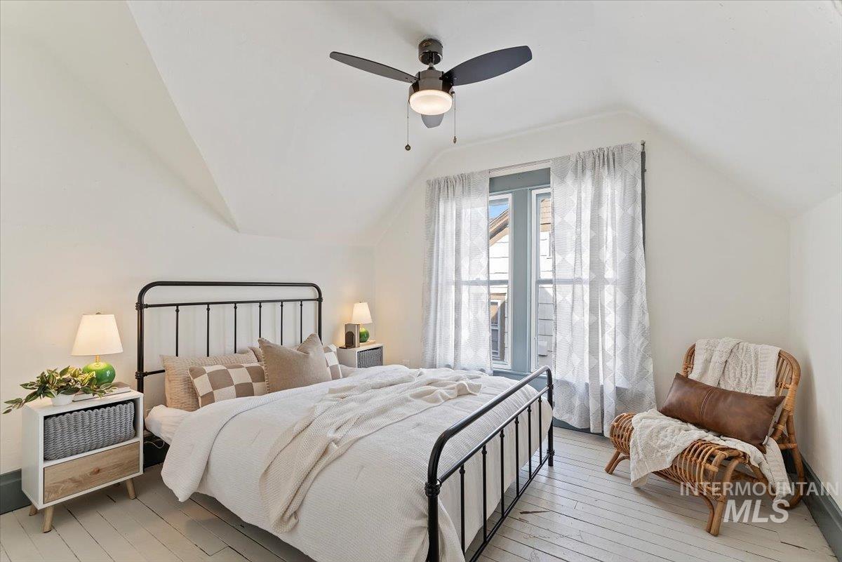 Bedroom featuring light wood finished floors, ceiling fan, and lofted ceiling
