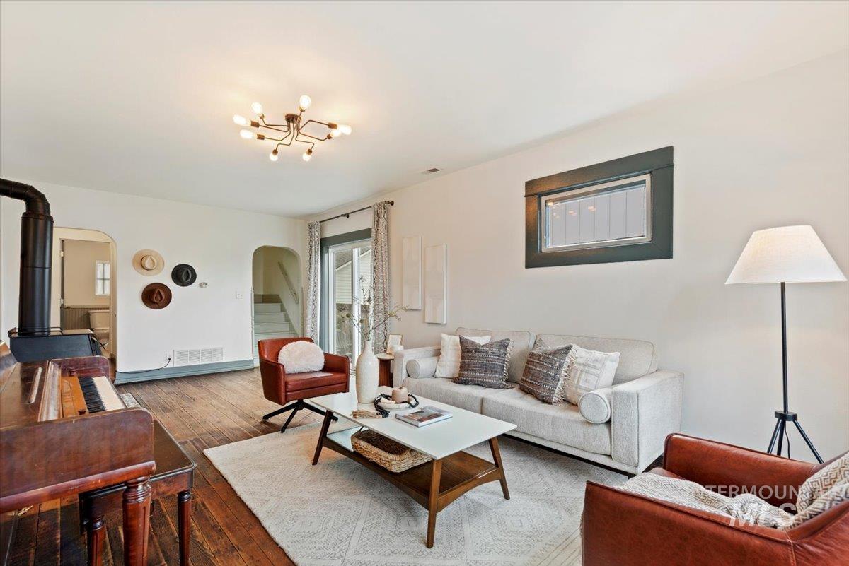Living area with hardwood / wood-style floors and arched walkways