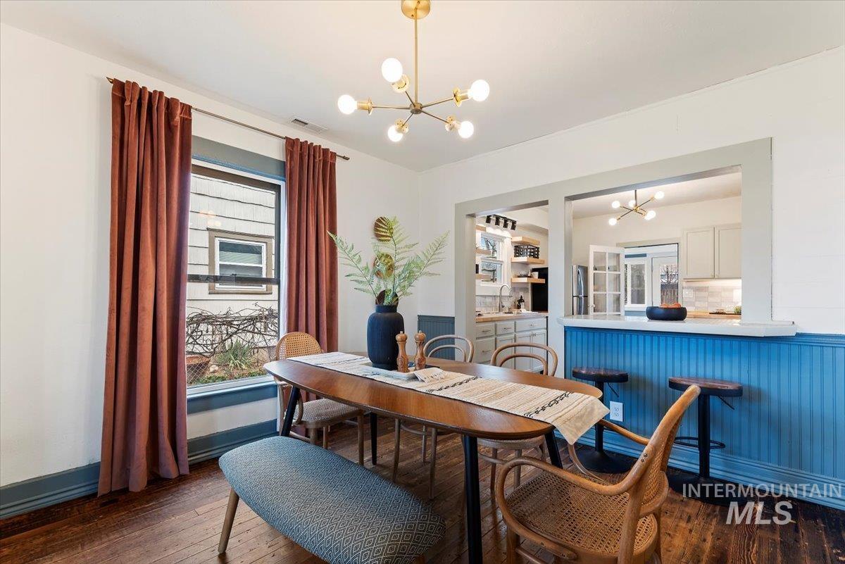 Dining space featuring a chandelier and dark wood-style flooring