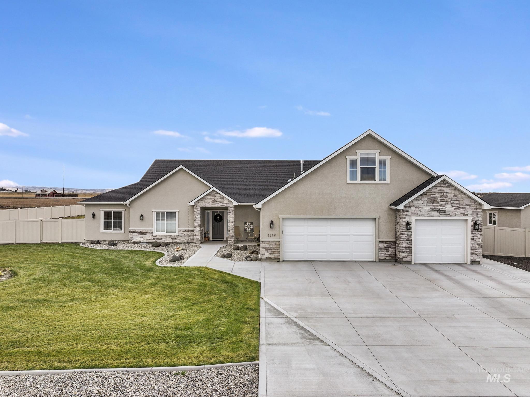 View of front of house featuring stucco siding, stone siding, and concrete driveway