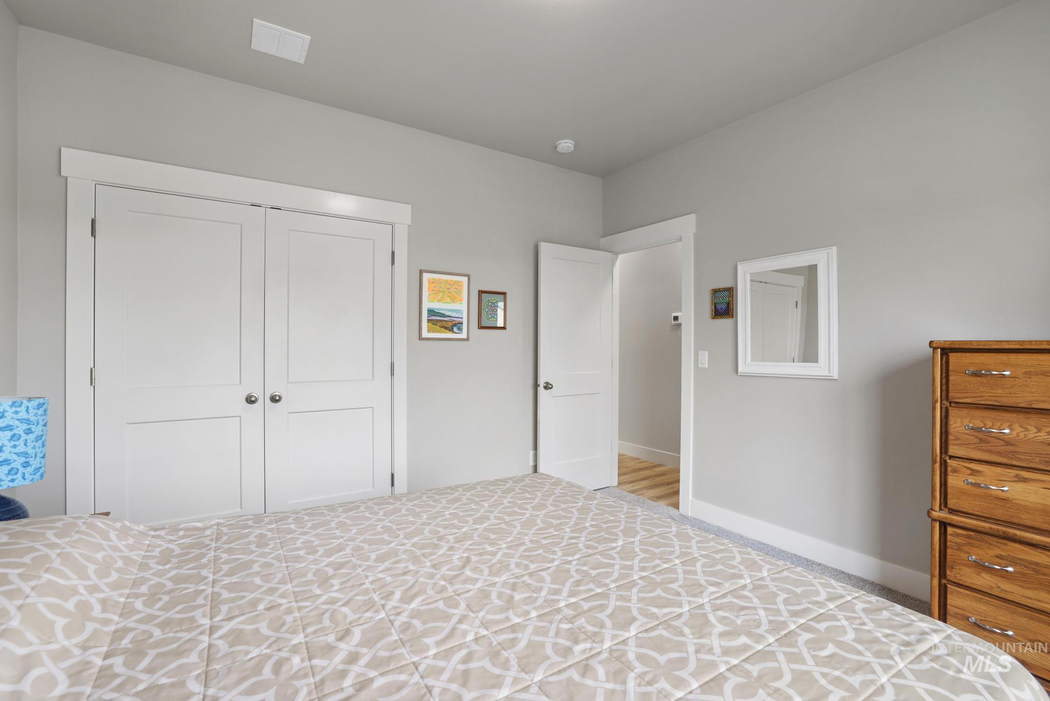 Carpeted bedroom featuring a closet and baseboards