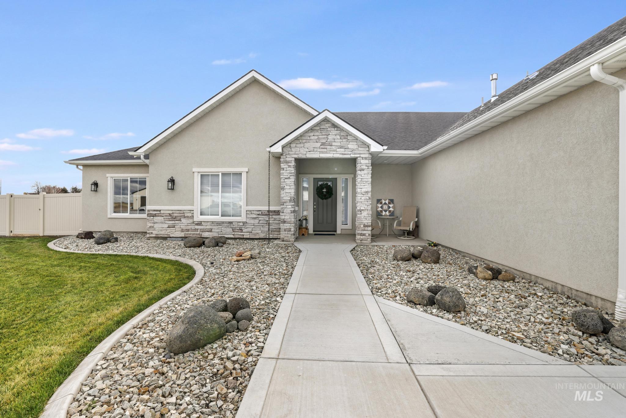View of exterior entry with stucco siding and stone siding