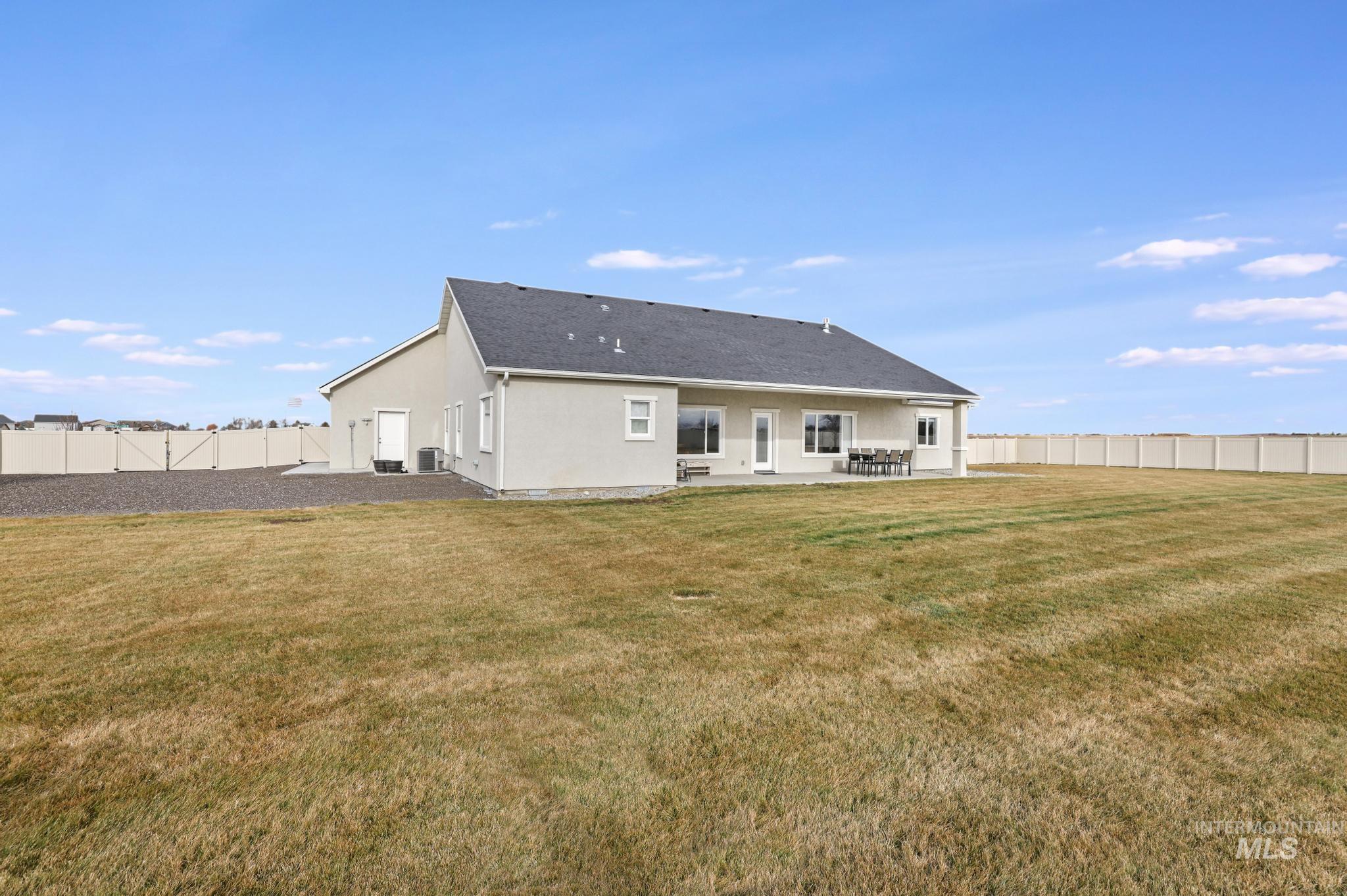 Rear view of house with a fenced backyard, stucco siding, and a patio