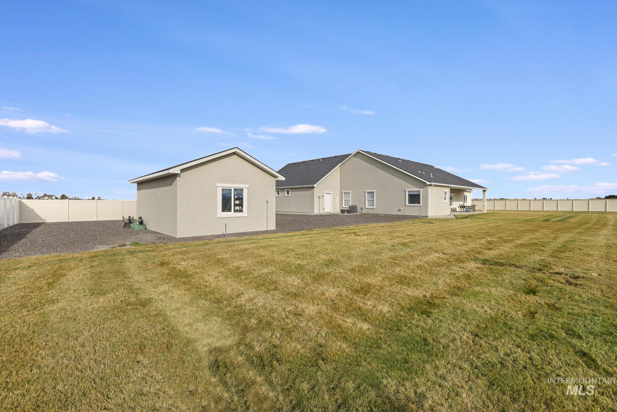Rear view of house with a fenced backyard and stucco siding