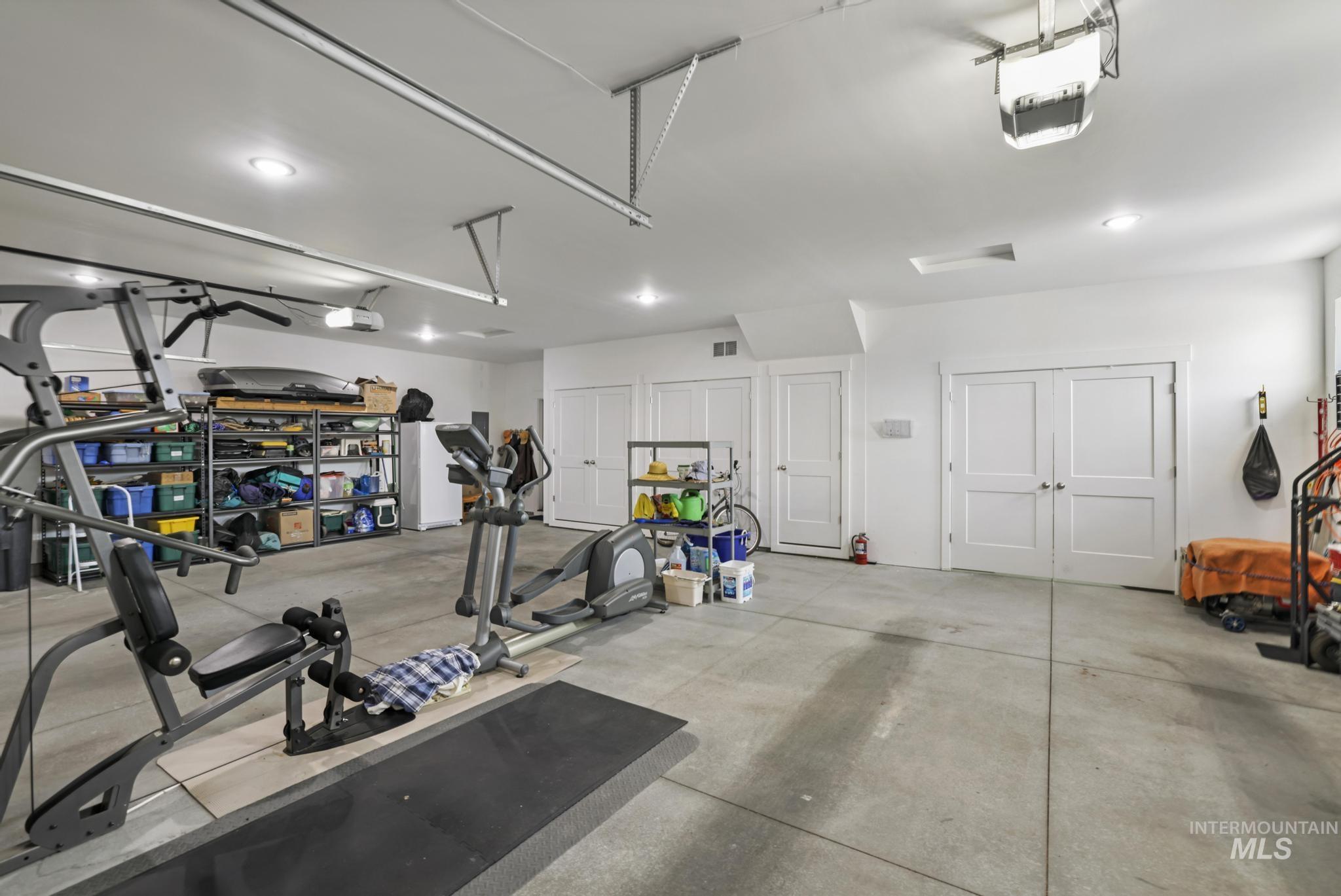 Garage with white refrigerator and a garage door opener