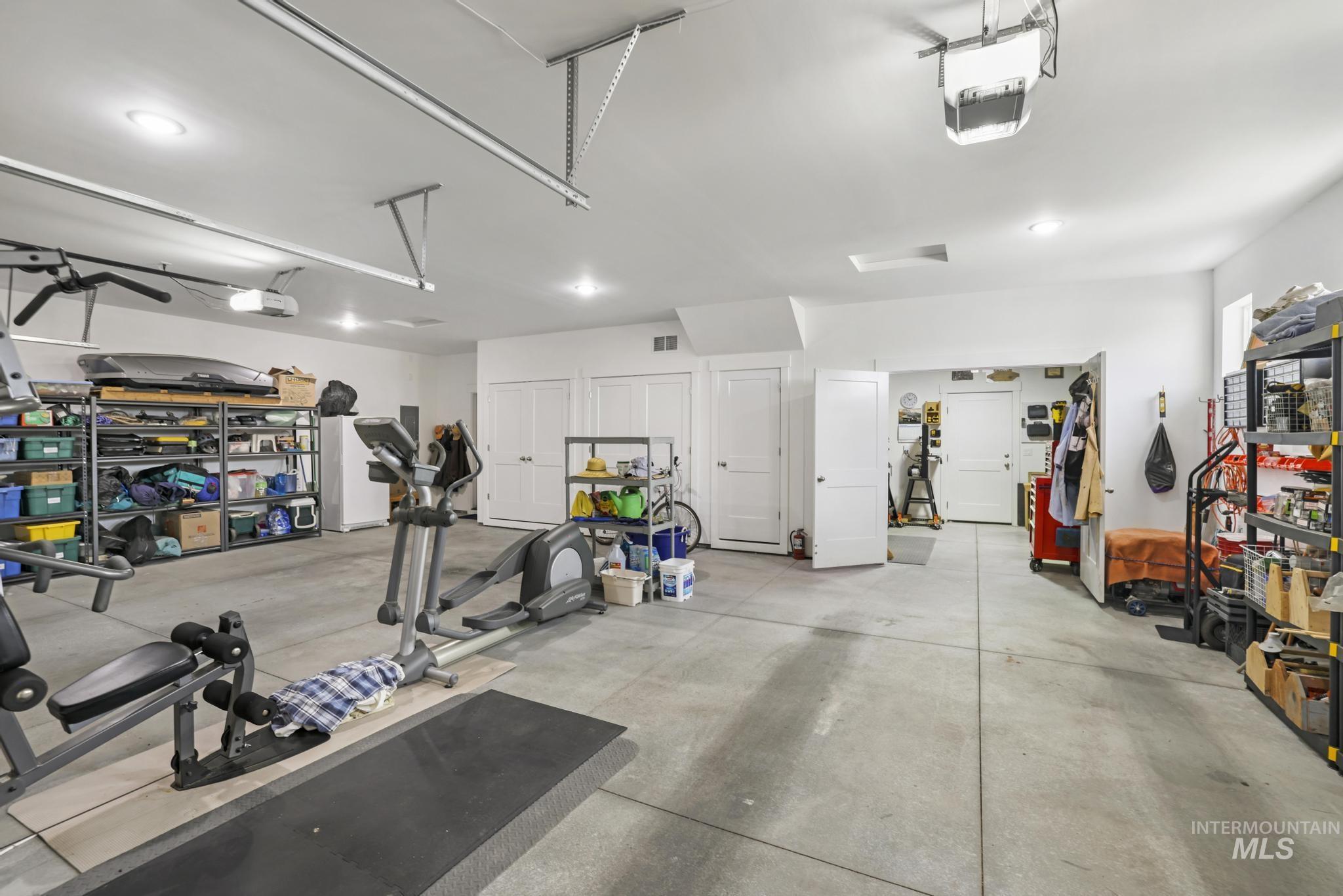 Garage with a garage door opener and freestanding refrigerator