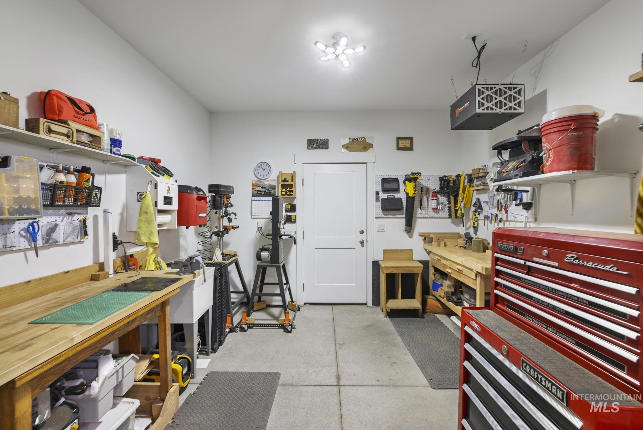 Garage featuring a workshop area and a heating unit