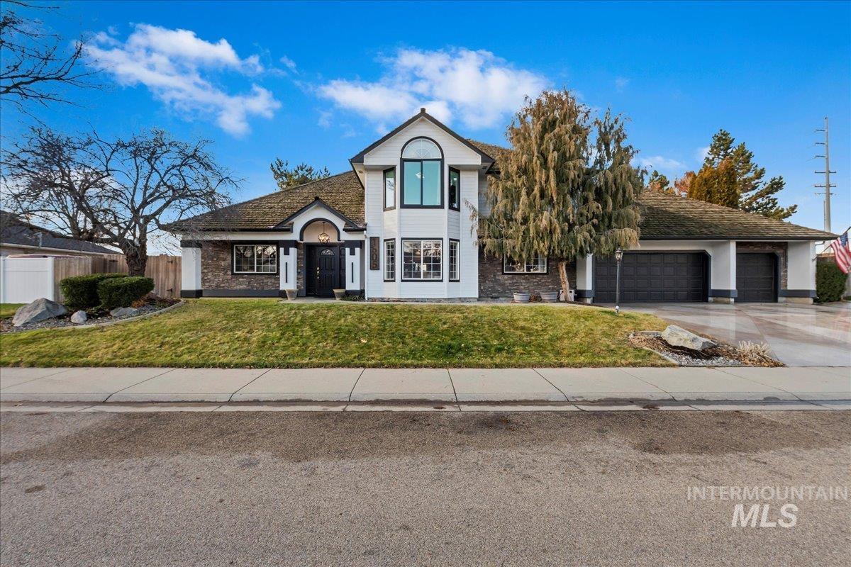 View of front of home featuring driveway, brick siding, and an attached garage