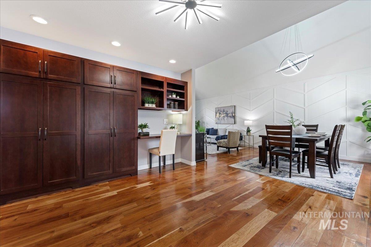 Dining room featuring light wood finished floors, a chandelier, built in study area, and recessed lighting
