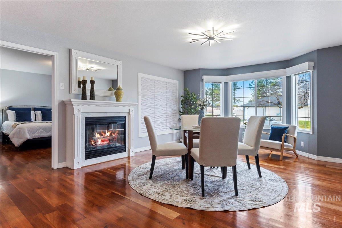 Dining area featuring a glass covered fireplace and wood finished floors