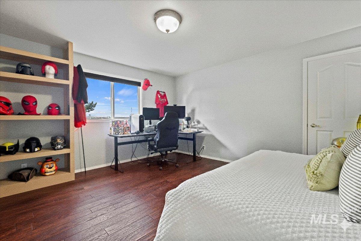 Bedroom featuring a desk and dark wood-style flooring