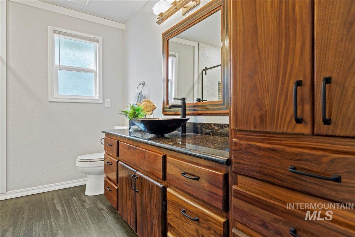 Bathroom with vanity, dark wood finished floors, and a shower