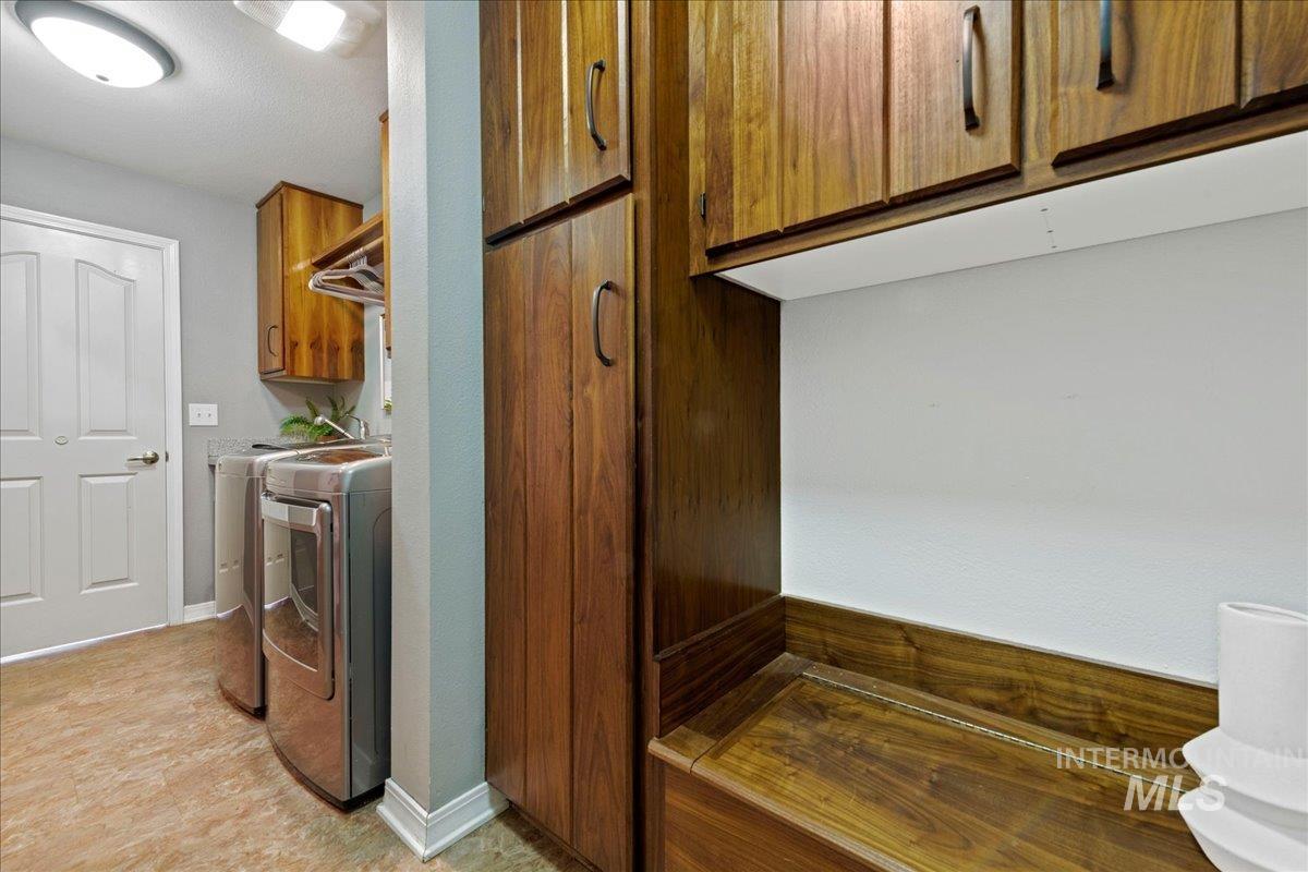 Washroom with washer and clothes dryer and baseboards