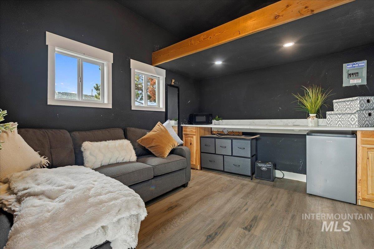 Living room with light wood-style flooring, recessed lighting, and beamed ceiling