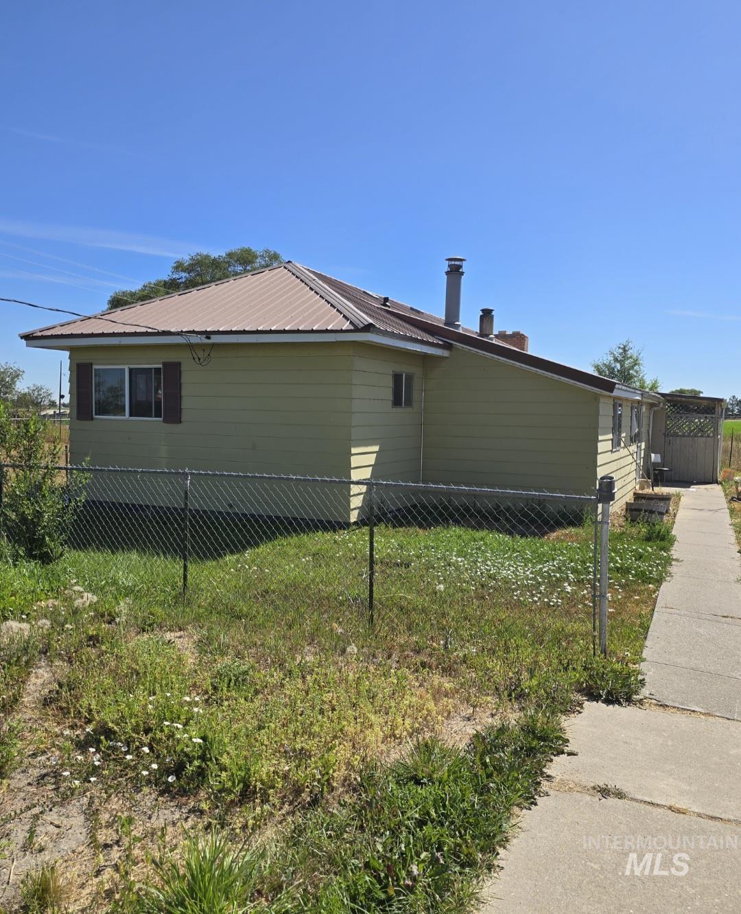 View of home's exterior with a metal roof and a chimney