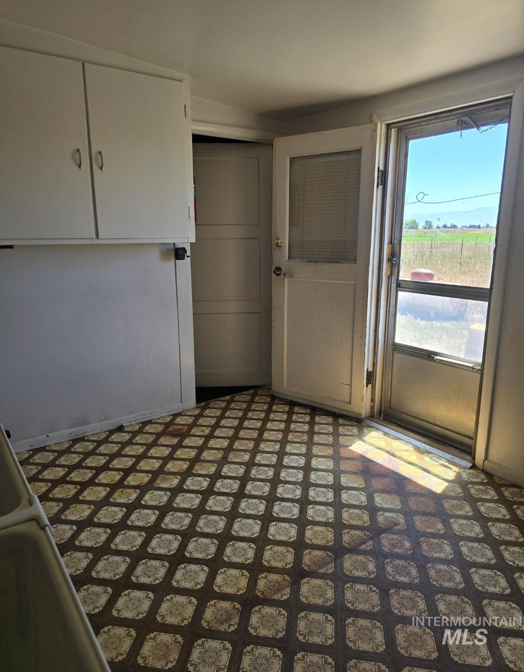 Interior space with white cabinets and dark flooring