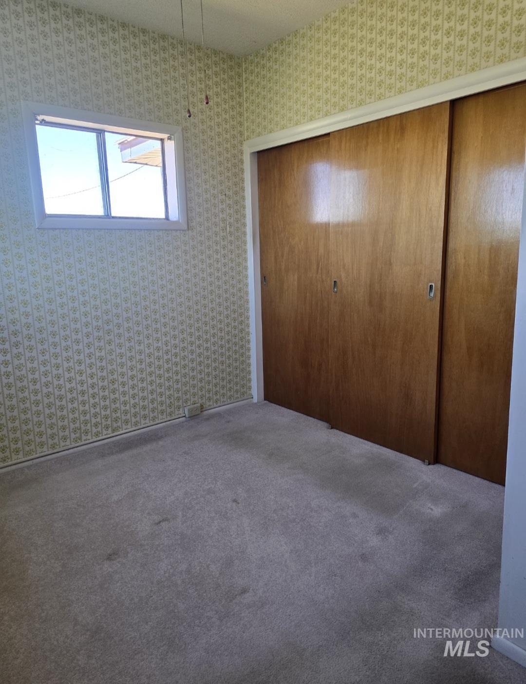 Unfurnished bedroom with a closet and carpet flooring