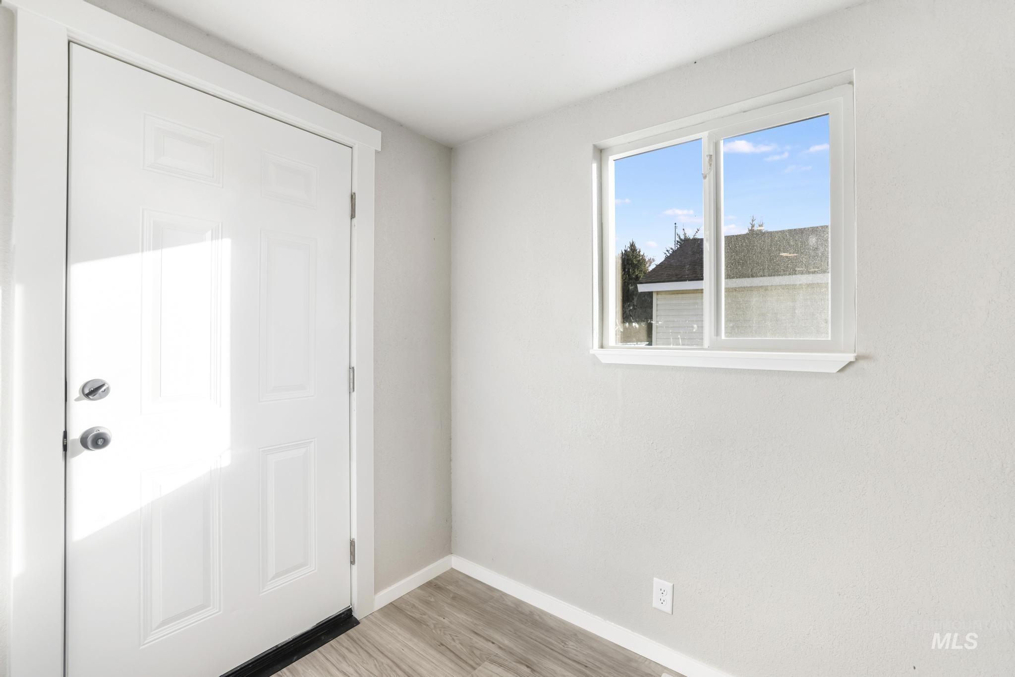 Entrance foyer featuring baseboards and light wood finished floors