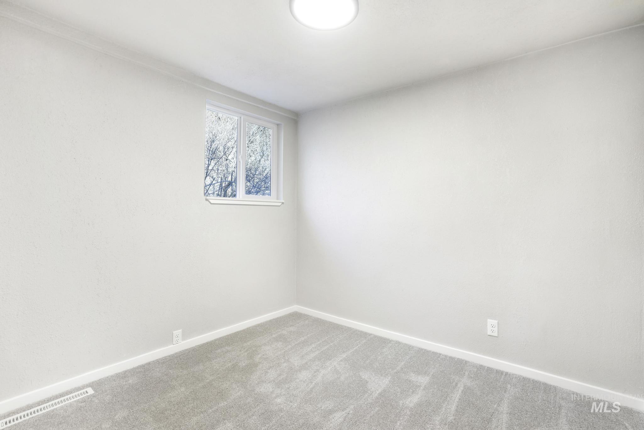 Carpeted empty bedroom with baseboards
