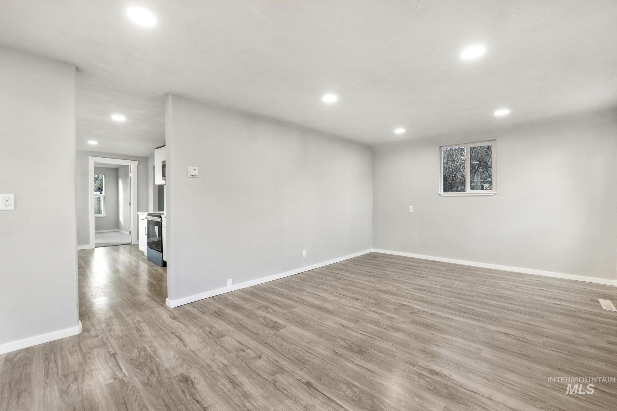 Living room with light wood-type flooring and recessed lighting