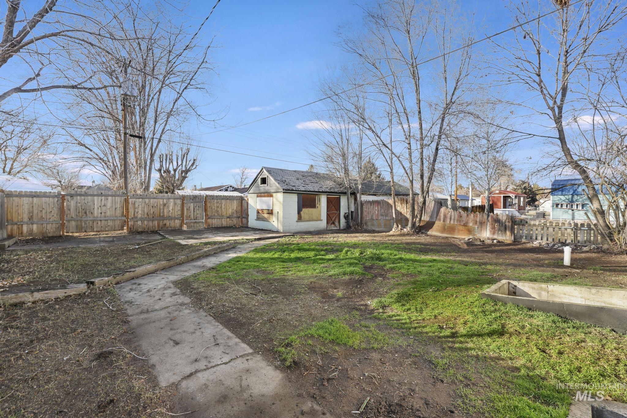 View of front of home featuring a fenced backyard and an outbuilding