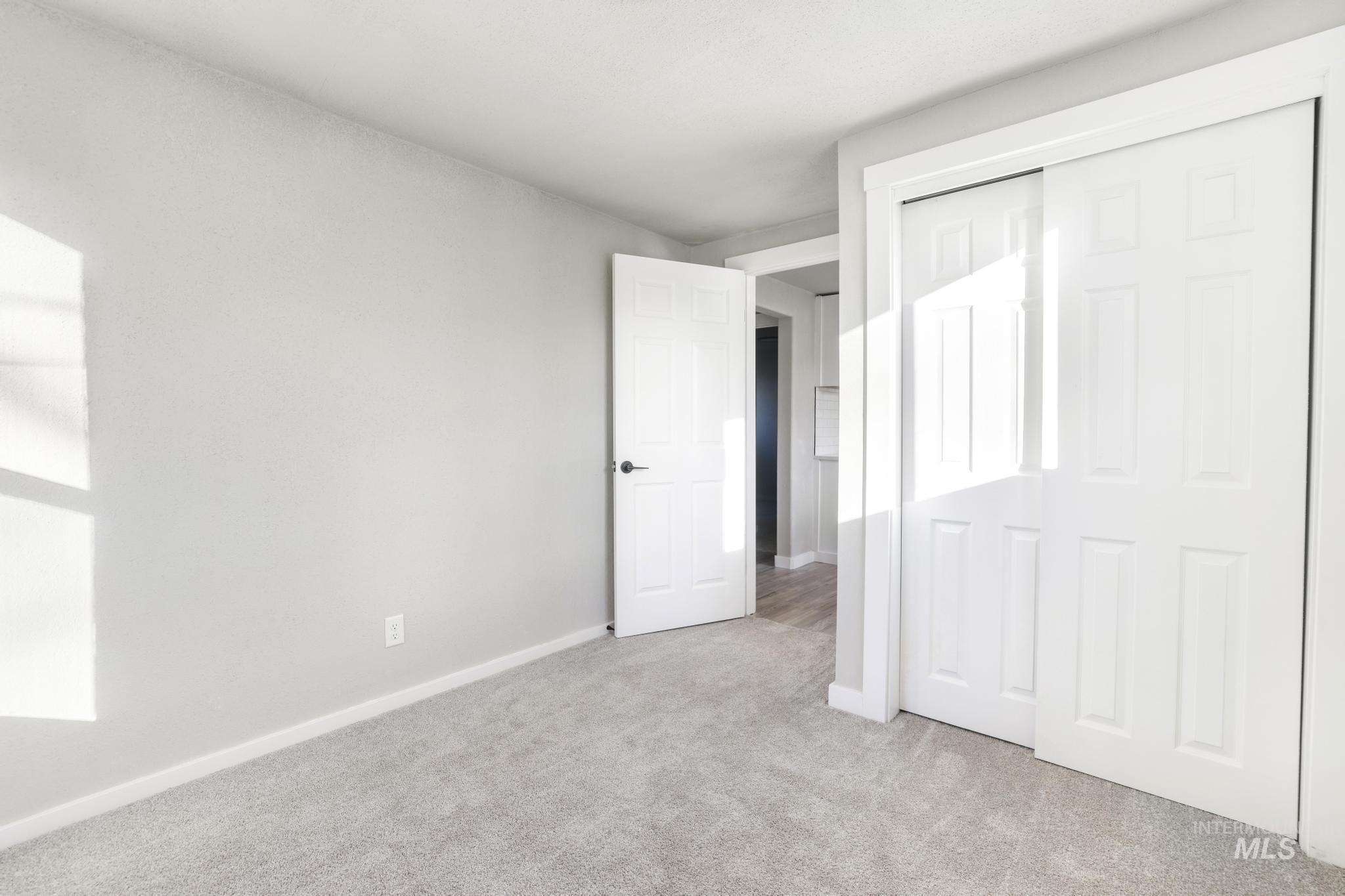 Unfurnished bedroom featuring light colored carpet and a closet