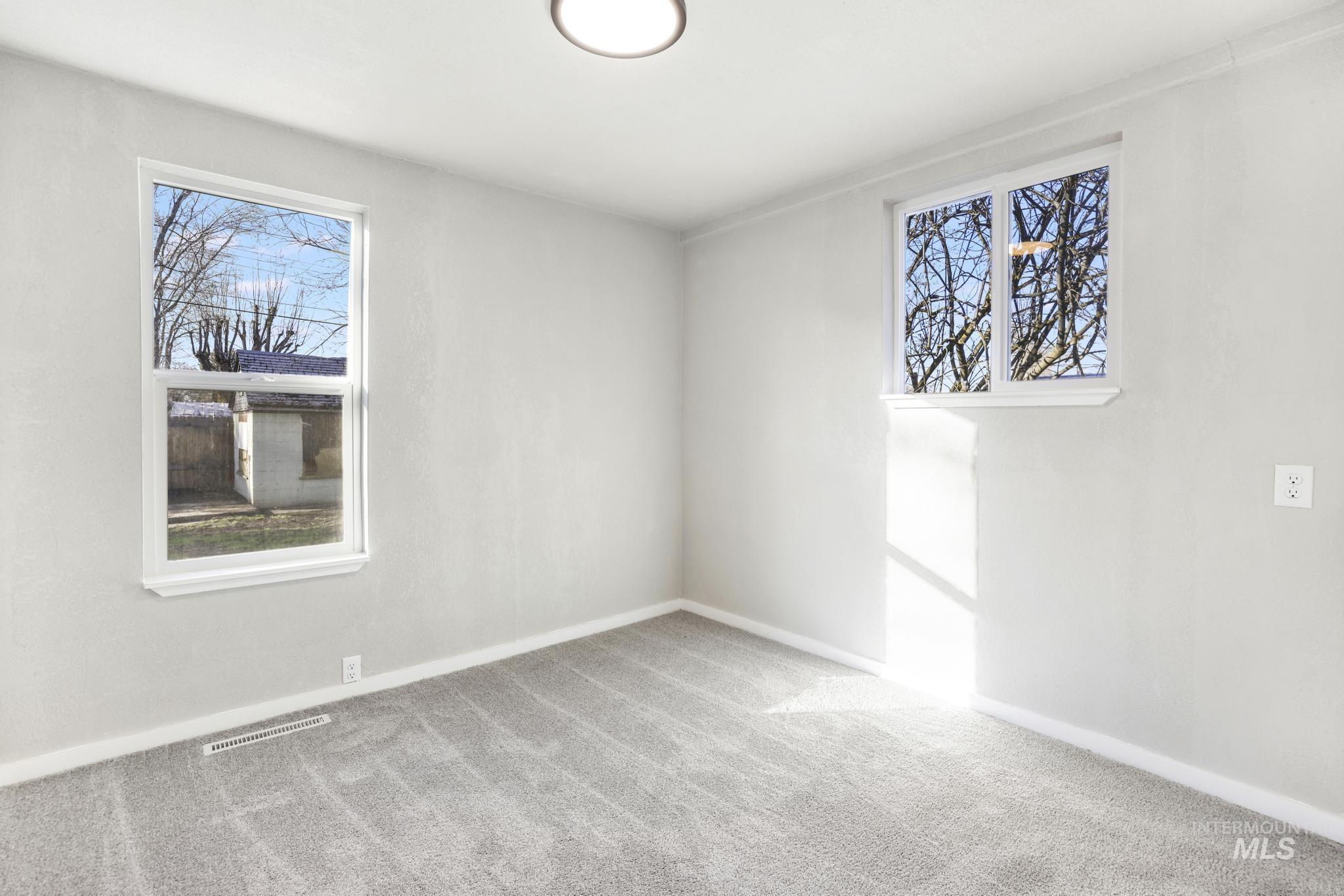 Carpeted bedroom featuring healthy amount of natural light